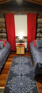 ロヴァニエミにあるPahtajan Majaのベッドルーム1室(ベッド2台、ランプ付きテーブル付)