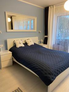 1 dormitorio con 1 cama grande y edredón azul en Apartament Nautica Pogorzelica, en Pogorzelica