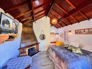 a bedroom with a bed and a fireplace at Estalagem da Montanha in Monte Verde