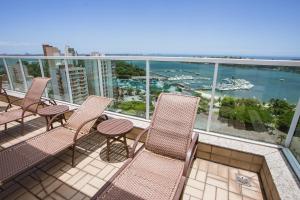 d'un balcon avec des chaises et une vue sur l'eau. dans l'établissement Praia do Canto Apart Hotel, à Vitória