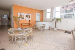 a room with tables and chairs in a building at Praia do Canto Apart Hotel in Vitória
