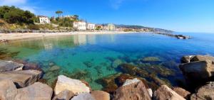 Blick auf einen Strand mit Felsen im Wasser in der Unterkunft Casa Cornice in Arma di Taggia