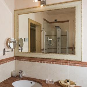 a bathroom with a sink, mirror, and toilet at Hotel B&B Andreas in Canazei