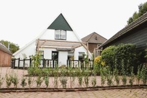 a white house with a fence in front of it at B&B t'Brocantje in Gramsbergen