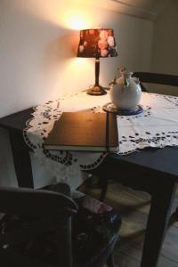 una mesa con una lámpara y un jarrón. en B&B t'Brocantje en Gramsbergen