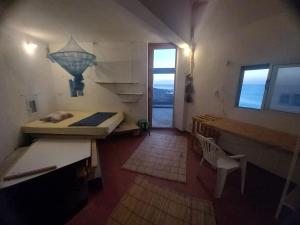 a room with a bed and a desk and a window at Casa Fabrice in Ribeira da Prata