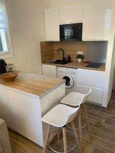 a kitchen with white cabinets and a sink and a dishwasher at Monaco Cosy Studio in Roquebrune-Cap-Martin