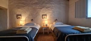 two beds sitting next to each other in a room at Monte do Arneiro in Sousel