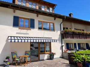 uma casa com uma varanda, uma mesa e cadeiras em Ferienwohnung Falkenstein em Rettenberg