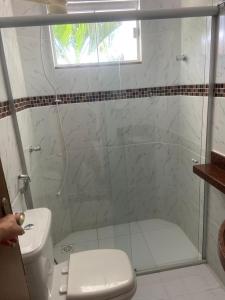 a bathroom with a glass shower with a toilet at Flat 09 in Conde