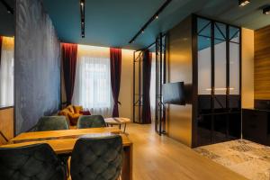 sala de estar con mesa, sillas y sofá en Lofty Exclusive Apartments en Sarajevo