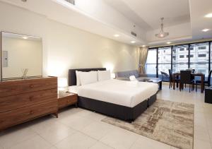 迪拜RH- Cozy Studio, Al Waleed , Cluster R, JLT的一间带大床的卧室和一间客厅