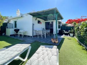 a backyard with a patio with a table and chairs at cozy & modern bungalow w/private garden bbq+wifi in Maspalomas