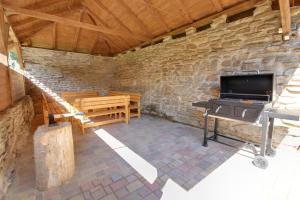 a living room with a stone wall and a stove at Chalupa Tomášek v blízkosti ski areálu in Dolni Dvur
