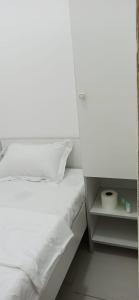 een slaapkamer met een wit bed en een witte kast bij Cozy Rooms and Small Partitions for Men guests in Dubai in Dubai