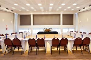 sala konferencyjna z długim stołem i krzesłami w obiekcie San Diego Suites Veredas Sete Lagoas w mieście Sete Lagoas