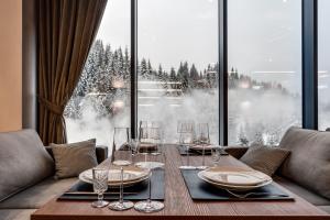 a table with glasses and plates on it in front of a window at GirskiDelux in Bukovel