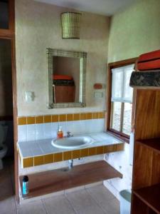 a bathroom with a sink and a mirror at Hotel Bahia Taitza in San José