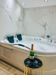 a bath tub with a bottle of champagne and two glasses at Guesthouse Dabić in Zlatibor