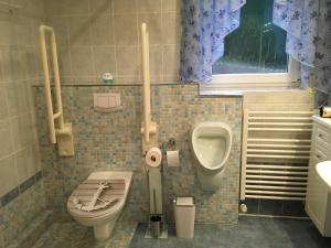 uma casa de banho com um WC, um urinol e um lavatório em Berta em Neunkirchen