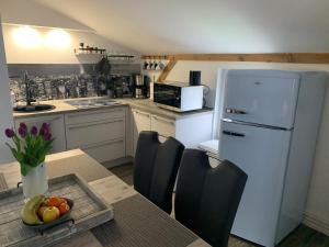 a kitchen with a table and a white refrigerator at FEWO Hoppegarten in Hoppegarten