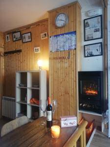 a room with a table with a fireplace and a clock at APARTAMENTO LOS VALLES en SIERRA NEVADA Parking gratuito in Sierra Nevada