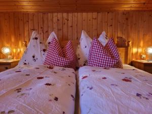 sypialnia z 2 łóżkami i białymi i czerwonymi poduszkami w obiekcie Gästehaus Bergwald w mieście Virgen