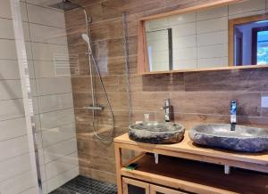 a bathroom with two sinks and a shower at Chalet de charme avec terrasse, jardin et sauna extérieur in Chapelle-des-Bois