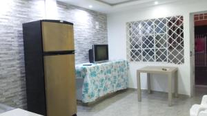 a refrigerator in a room with a table and a tv at Apartamento como en casa in Soledad