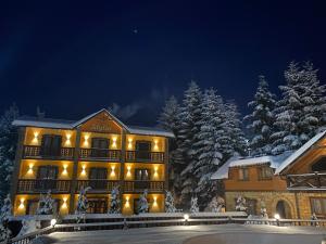 a hotel in the snow at night at Idylia Grand Villas in Migovo
