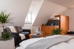 a living room with a couch a chair and a living room at Hotel am Ludwigskanal in Wendelstein +38 photos