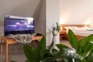 a living room with a television and a bed at Hotel am Ludwigskanal in Wendelstein