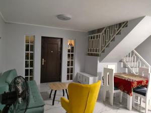 a living room with a table and yellow chairs at Lucky Swiss Transient House Alaminos - Entire House near Hundred Islands in Bolo