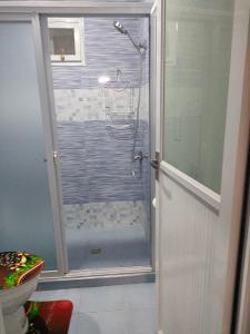 ein Bad mit einer Dusche und einer Glastür in der Unterkunft Lucky Swiss Transient House Alaminos - Entire House near Hundred Islands in Bolo