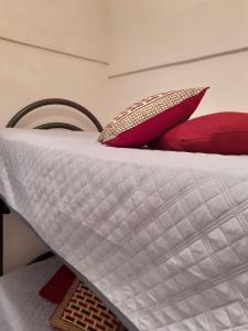 a close up of a bed with red pillows at Il Dammuso di Tracino in Pantelleria