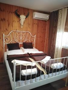 een slaapkamer met een bed met een stierenkop aan de muur bij Lipics Part in Murarátka