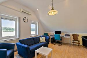 B & B Leudal في Haelen: غرفة معيشة بأثاث ازرق وساعة على الحائط