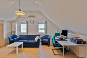 B & B Leudal في Haelen: غرفة معيشة مع أريكة زرقاء ومكتب