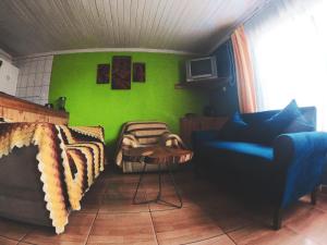 a living room with a couch and a green wall at Los Rukos Cabanas (Bungalows) in Pichilemu