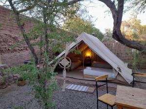 a white tent with a couch and a table at Aji Verde Hostel San Pedro in San Pedro de Atacama