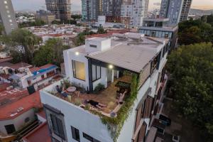 a white house with a rooftop garden on a city at BOHOSTEL in Guadalajara