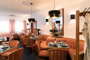 un restaurant avec des tables, des chaises et un miroir dans l'établissement Hotel am Ludwigskanal, à Wendelstein