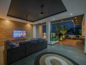 a living room with a couch and a flat screen tv at Villa Mimpi Bali in Jimbaran