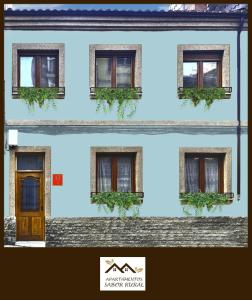 a building with a door and plants in the windows at Apartamentos Sabor Rural I in León