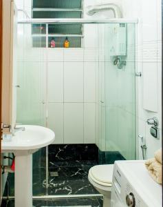y baño con ducha de cristal y aseo. en Lindo apartamento de 2 quartos ao lado da Praia de Copacabana!, en Río de Janeiro