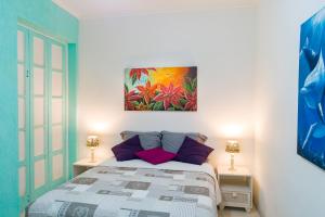 a bedroom with a bed and a painting on the wall at Lindo apartamento de 2 quartos ao lado da Praia de Copacabana! in Rio de Janeiro