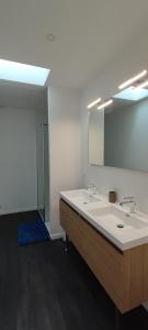 uma casa de banho com um lavatório branco e um espelho. em BARTHOME em Taissy