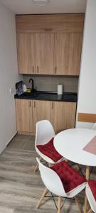 cocina con mesa, mesa blanca y sillas en Snowman Studio Apartment Jahorina en Jahorina