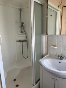 a white bathroom with a shower and a sink at Jade's Haven - Pet friendly, Ingoldmells in Ingoldmells