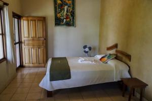 1 dormitorio con 1 cama en una habitación con ventana en Hotel Bahia Taitza, en San José